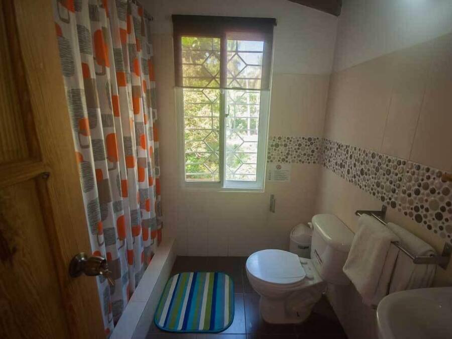 Un baño con bañera, inodoro y ventana.