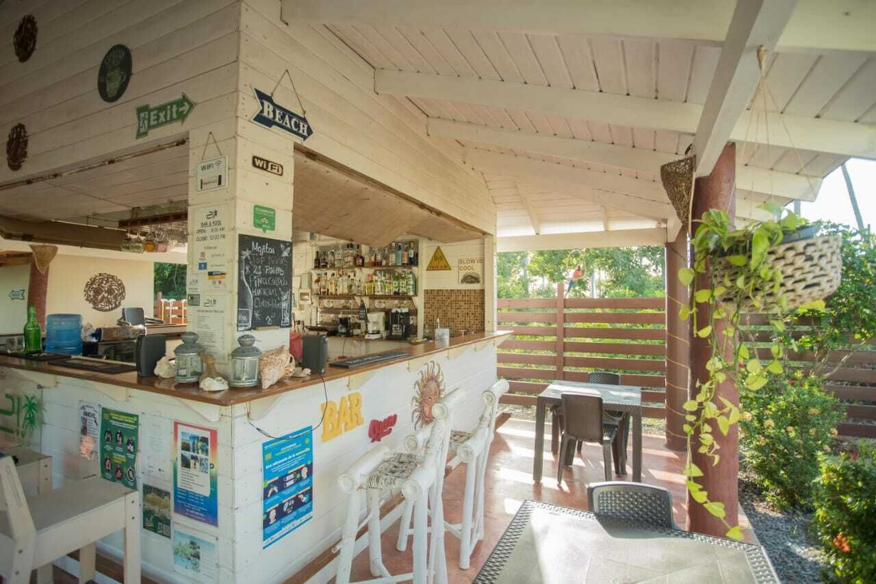 A beach-themed bar with a counter, seating area, and outdoor patio.