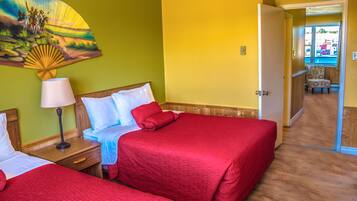 Habitación de hotel con dos camas, una mesita de noche con lámpara, un cuadro en la pared y vistas al área de la piscina.