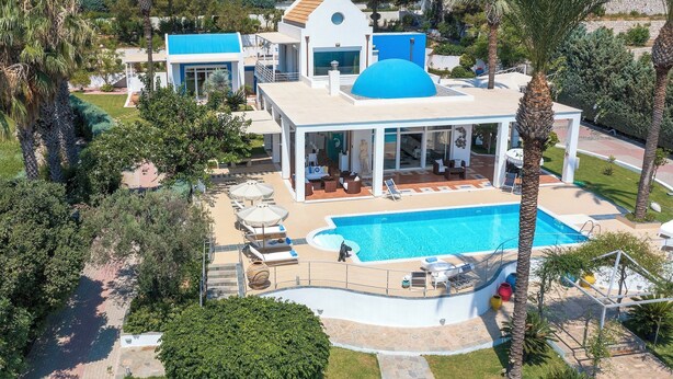 A modern house with a large pool, surrounded by palm trees and a well-maintained lawn. - Grande Dame Villa of Rhodes (Rhodes)