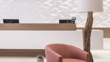 Een modern ingerichte receptie met een receptiebalie, een lamp en zitgedeelte.