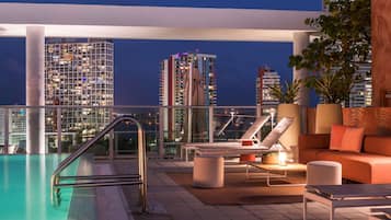 Relax on the rooftop terrace with a pool, lounge chairs, and a sofa set, offering stunning city views.