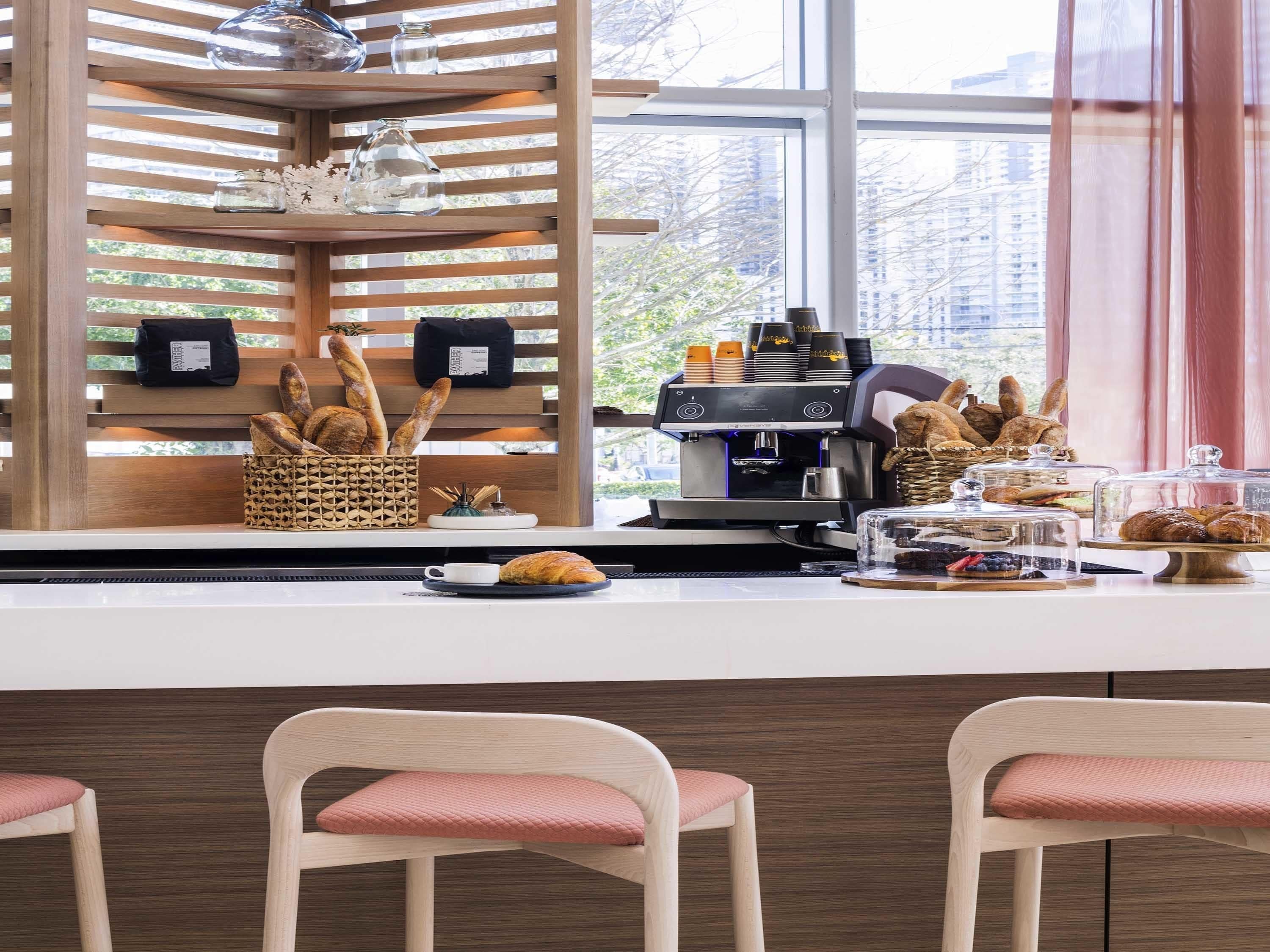 A café with a coffee machine, pastries, and seating.