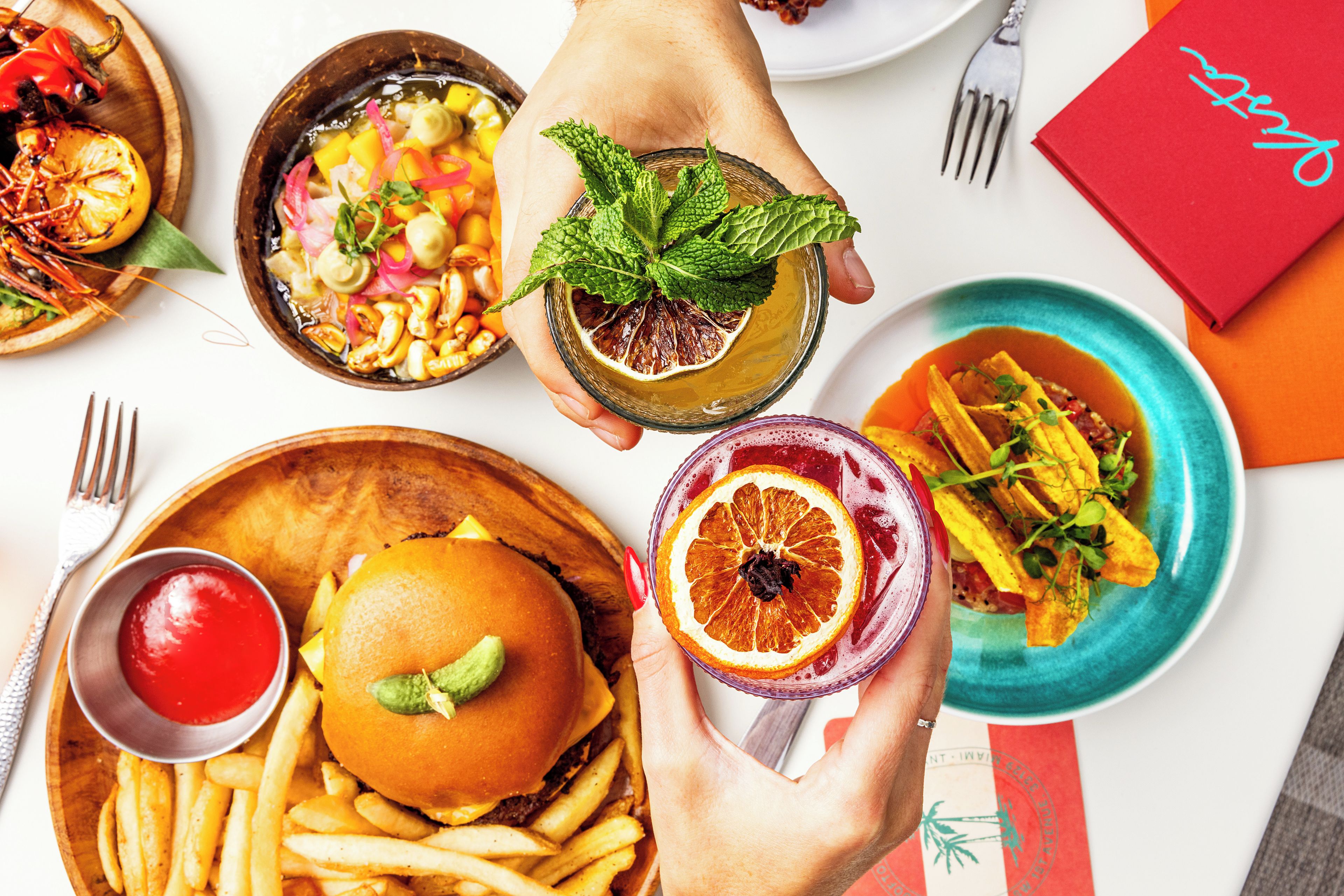 A variety of dishes including a burger, fries, and a salad, suggesting a dining setting.
