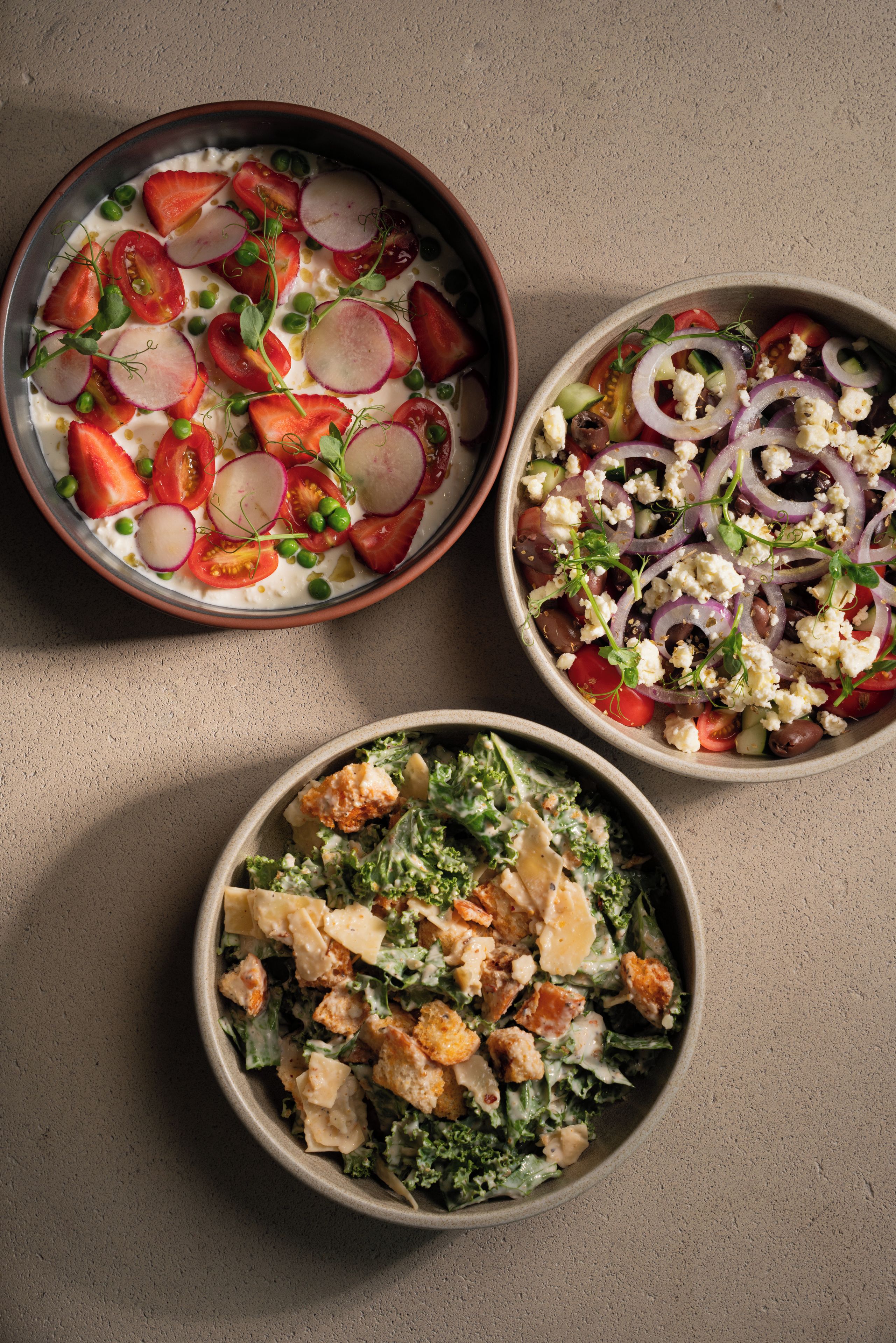 Tres ensaladas con ingredientes variados.