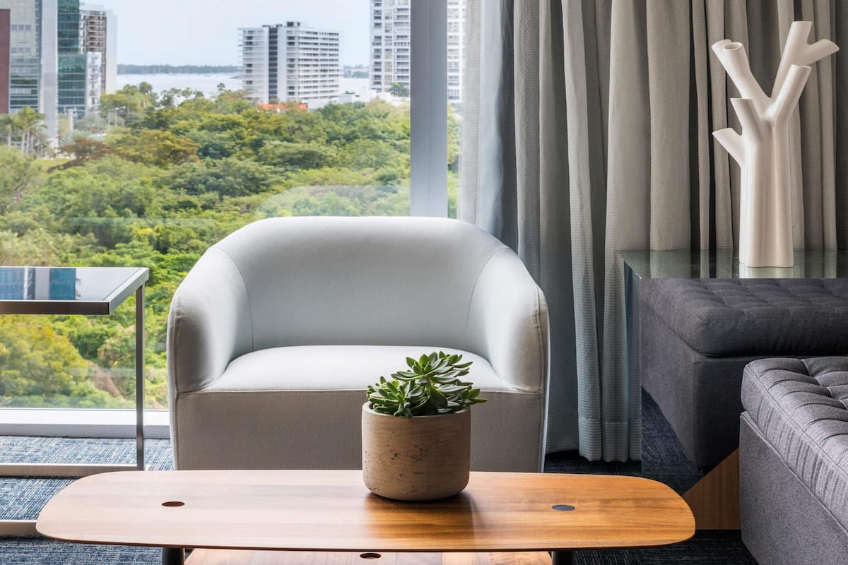 Una sala de estar moderna con vistas a un paisaje urbano y zonas verdes.