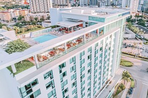Un hotel moderno con piscina en la azotea y zona de estar al aire libre.