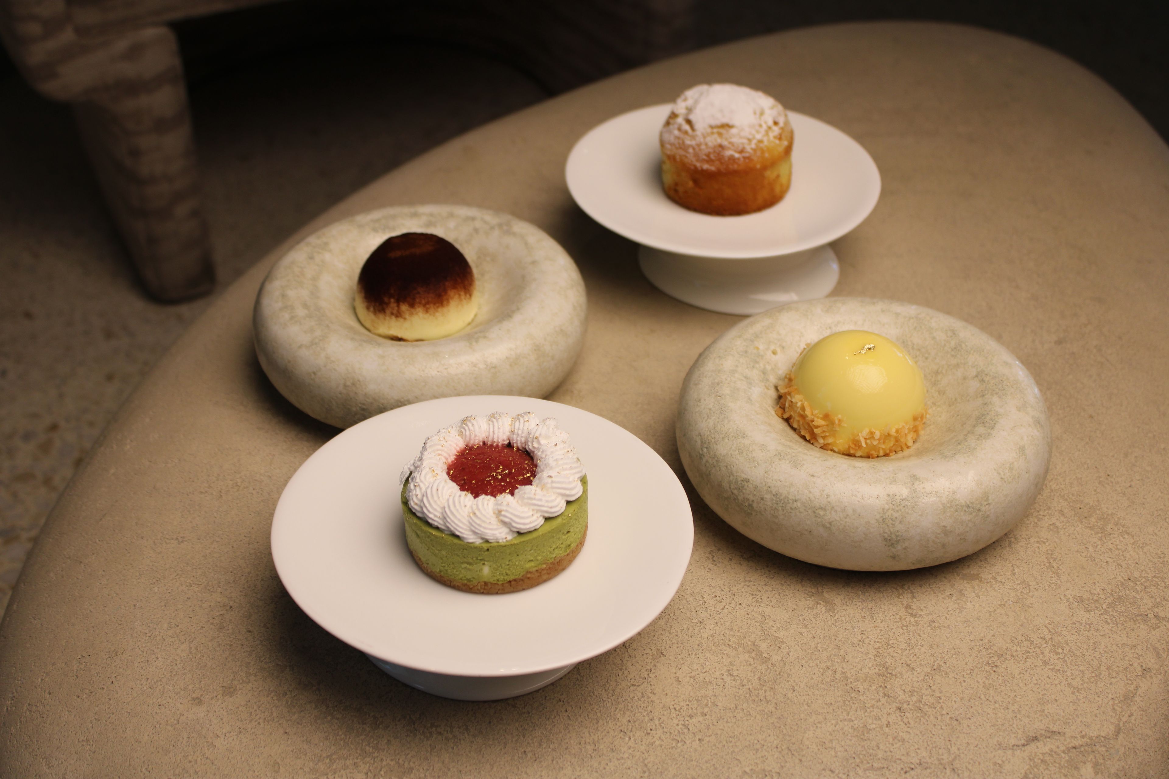 Four dessert items on white plates.