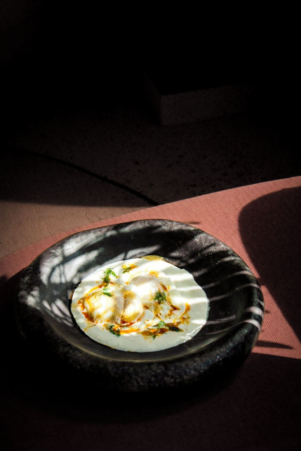 A plate of food on a dark stone surface.