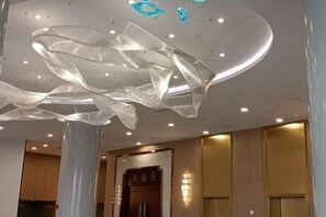 A modern interior with a unique ceiling design, a reception area, and a wooden door. - Fulaidun Business Hotel (Ningbo Airport Yadu Subway Station) (NINGBO)