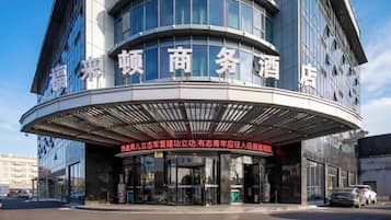 A hotel with a curved entrance and signage in a foreign language.