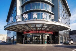 A hotel with a curved entrance and signage in a foreign language.