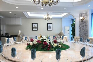 A round dining table with chairs, a chandelier, and a floral centerpiece. - Fulaidun Business Hotel (Ningbo Airport Yadu Subway Station) (NINGBO)
