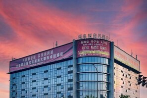 Un edificio moderno con amplios ventanales y varias indicaciones en la fachada.