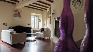A living room with a sofa, two armchairs, a coffee table, and a fireplace. - Italianway   - Argelati (Milan)