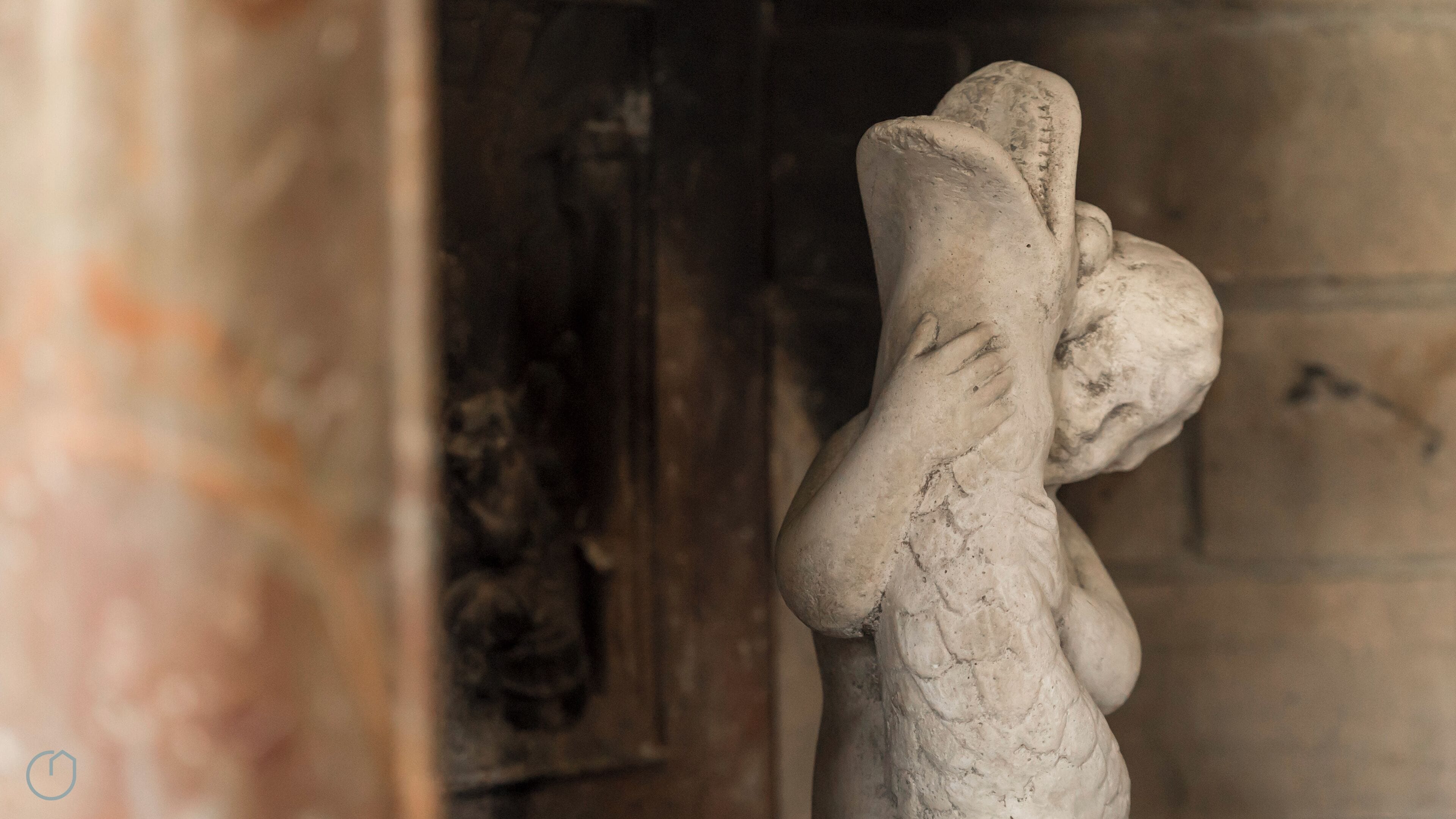 A close-up of a weathered stone sculpture with intricate carvings, likely part of an ancient structure or monument.