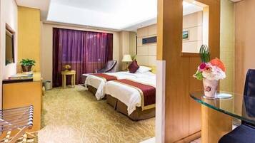 A hotel room with a large bed, two bedside tables, a desk, and a chair.