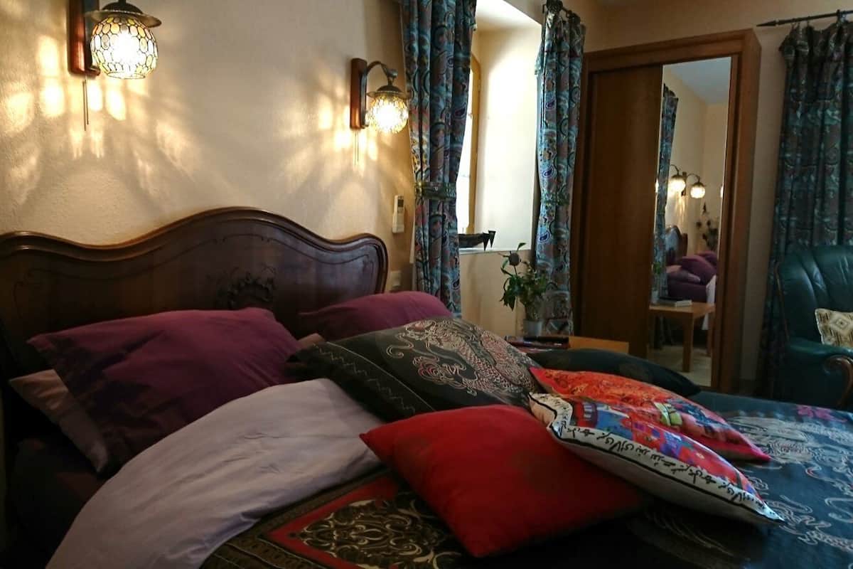Een bed met meerdere kussens en een beddegoed met een patroon.