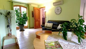Una sala de estar con un sofá, una mesa de centro y plantas en macetas.