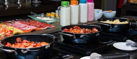 A buffet with various food items and condiments.