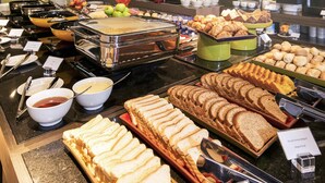 A buffet with various food items including bread, pastries, and fruits. - Novotel Santos Gonzaga (Santos)
