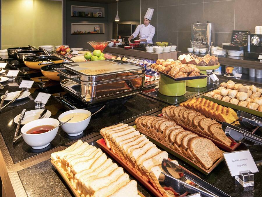 A buffet with various food items and a chef preparing food.