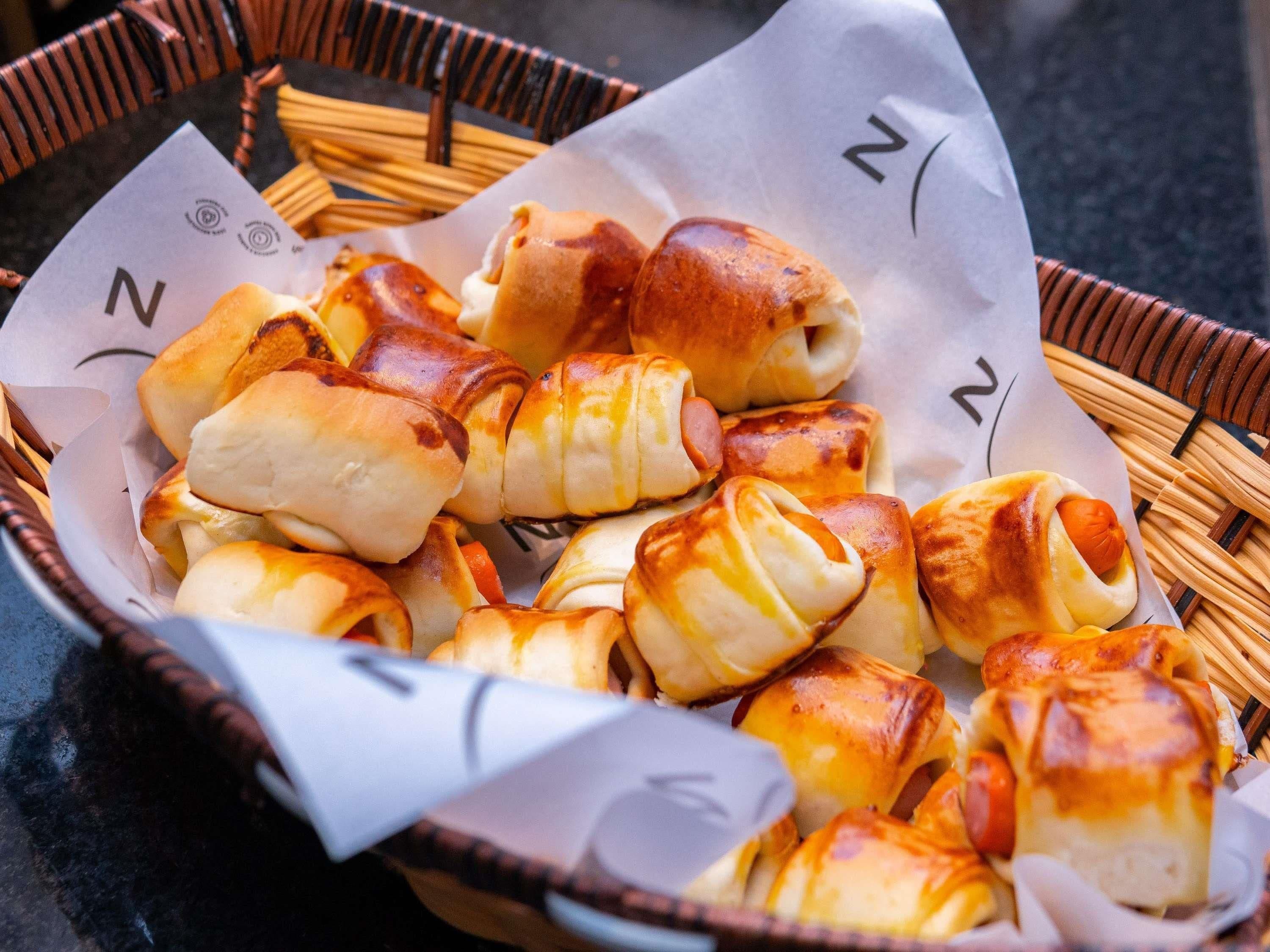 A basket of golden-brown pastries with a visible logo on the paper lining.