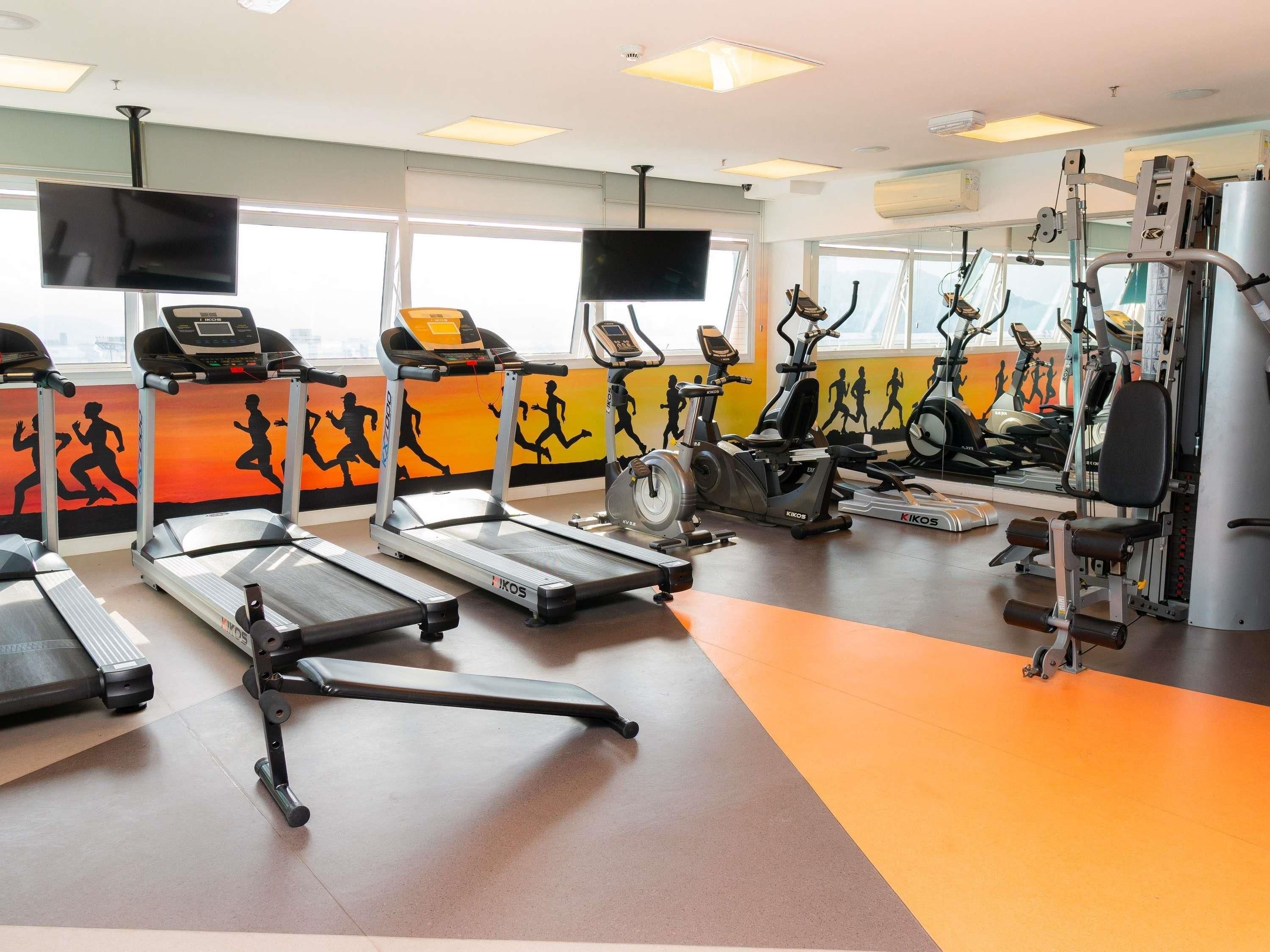 A gym with treadmills, elliptical machines, and weight equipment.
