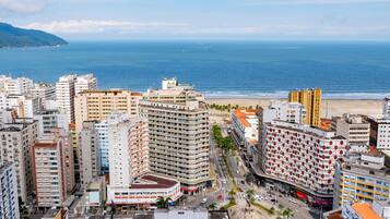 Un paisaje urbano costero con rascacielos, una playa y cielo despejado.