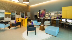A modern lobby with a reception desk, seating area, and bar. - Novotel Santos Gonzaga (Santos)
