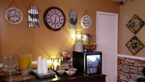 A kitchen area with a refrigerator, a coffee machine, and a fruit bowl. - Kansas Country Inn (Oakley)