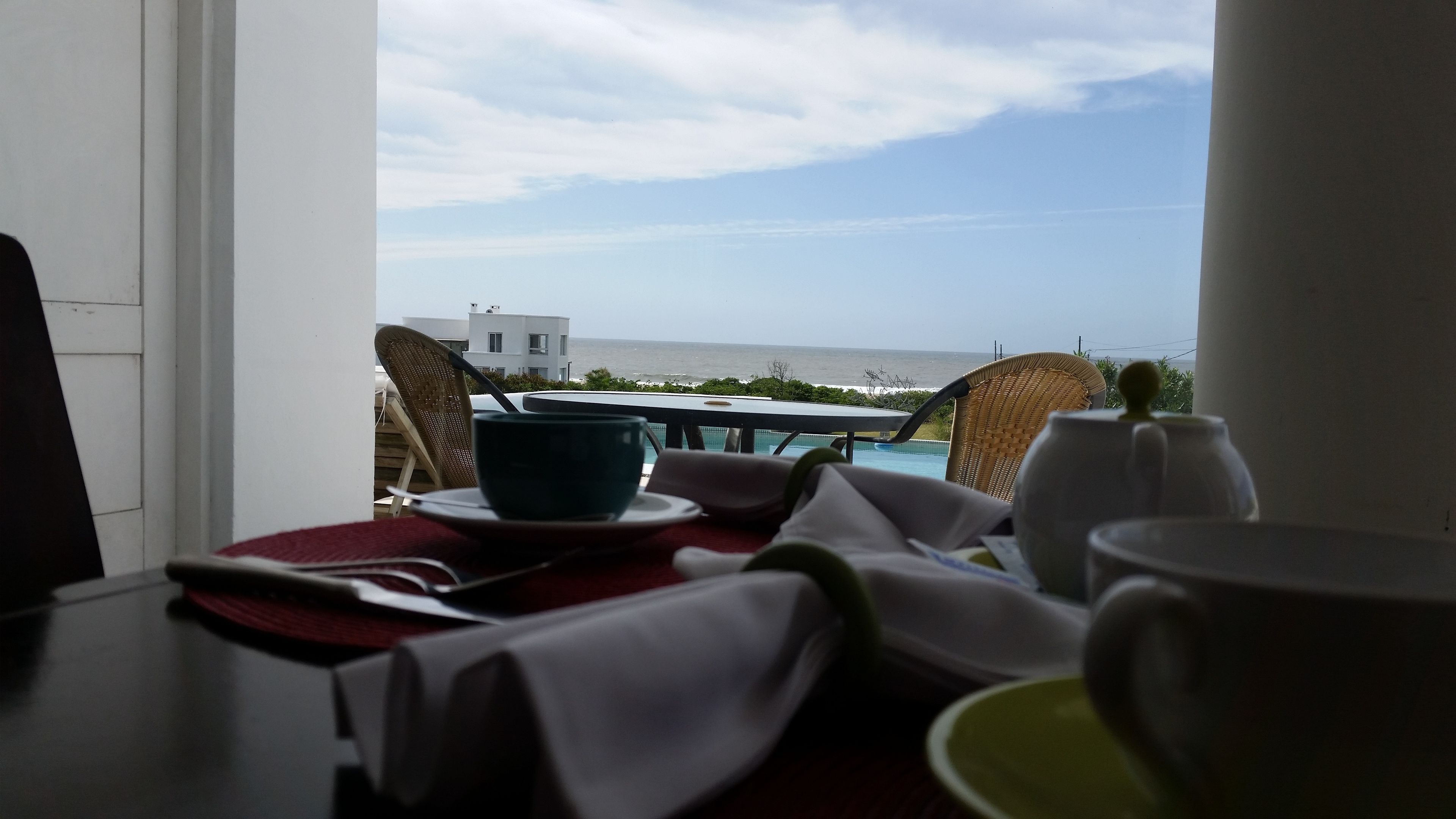 Una mesa de comedor con vista al océano y un edificio al otro lado del agua.
