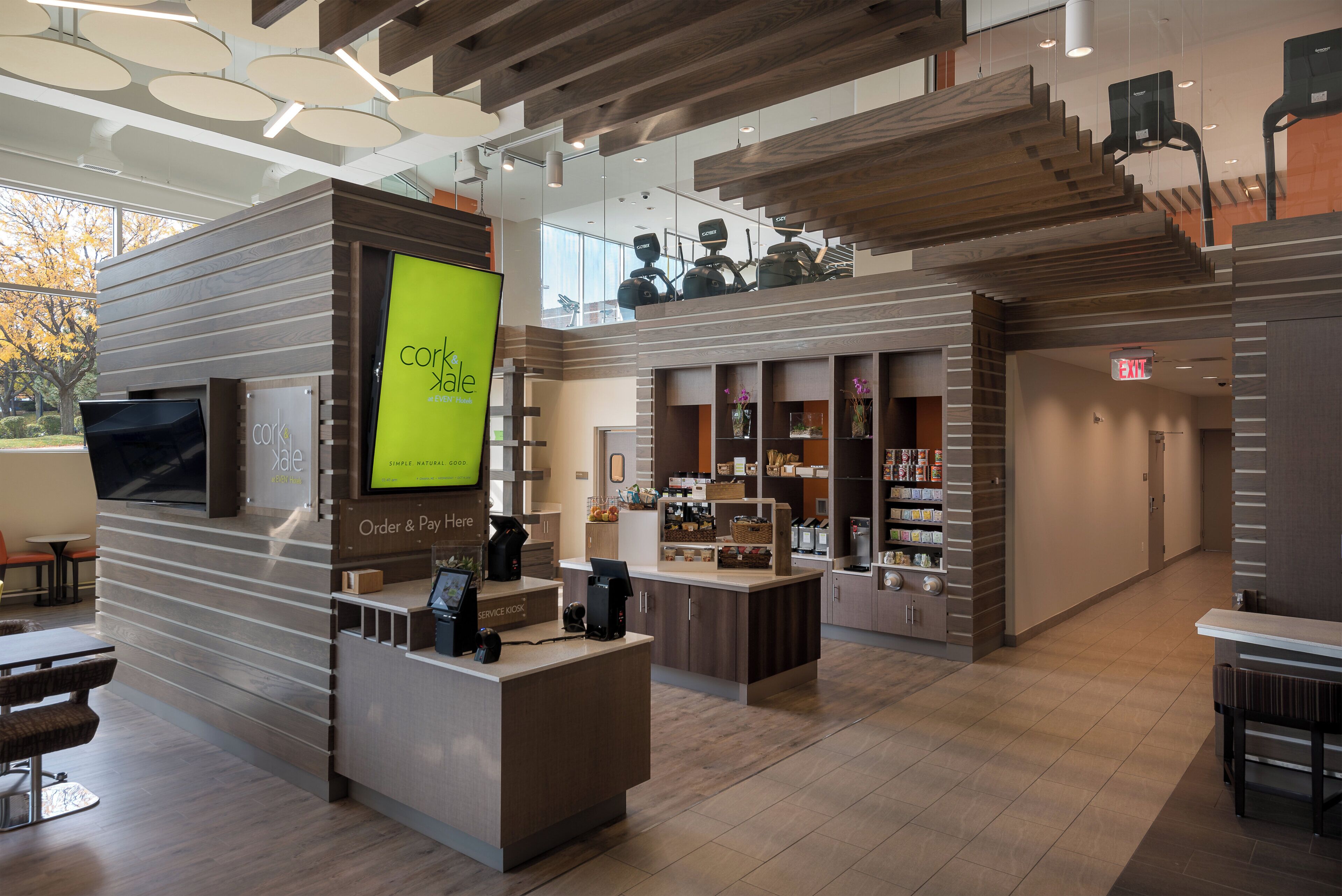 Un intérieur moderne comprenant un comptoir d’accueil, un espace salon et un escalier menant à un niveau supérieur.