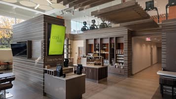 Un intérieur moderne comprenant un comptoir d’accueil, un espace salon et un escalier menant à un niveau supérieur.