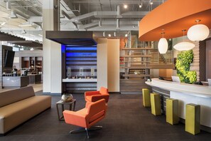 A modern reception area with a counter, seating, and a decorative wall.