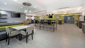 A modern dining area with a long bench, dining tables, and chairs.