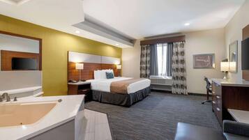 Hotelkamer met een groot bed, een bureau, een stoel, een televisie, een badkamer met een wastafel en spiegel, en een raam met gordijnen.