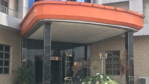 Um edifício moderno com fachada de vidro e telhado laranja curvo.