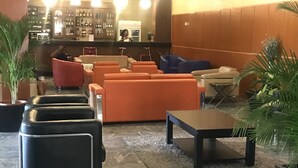 Um saguão com áreas de estar, um bar e uma recepção.