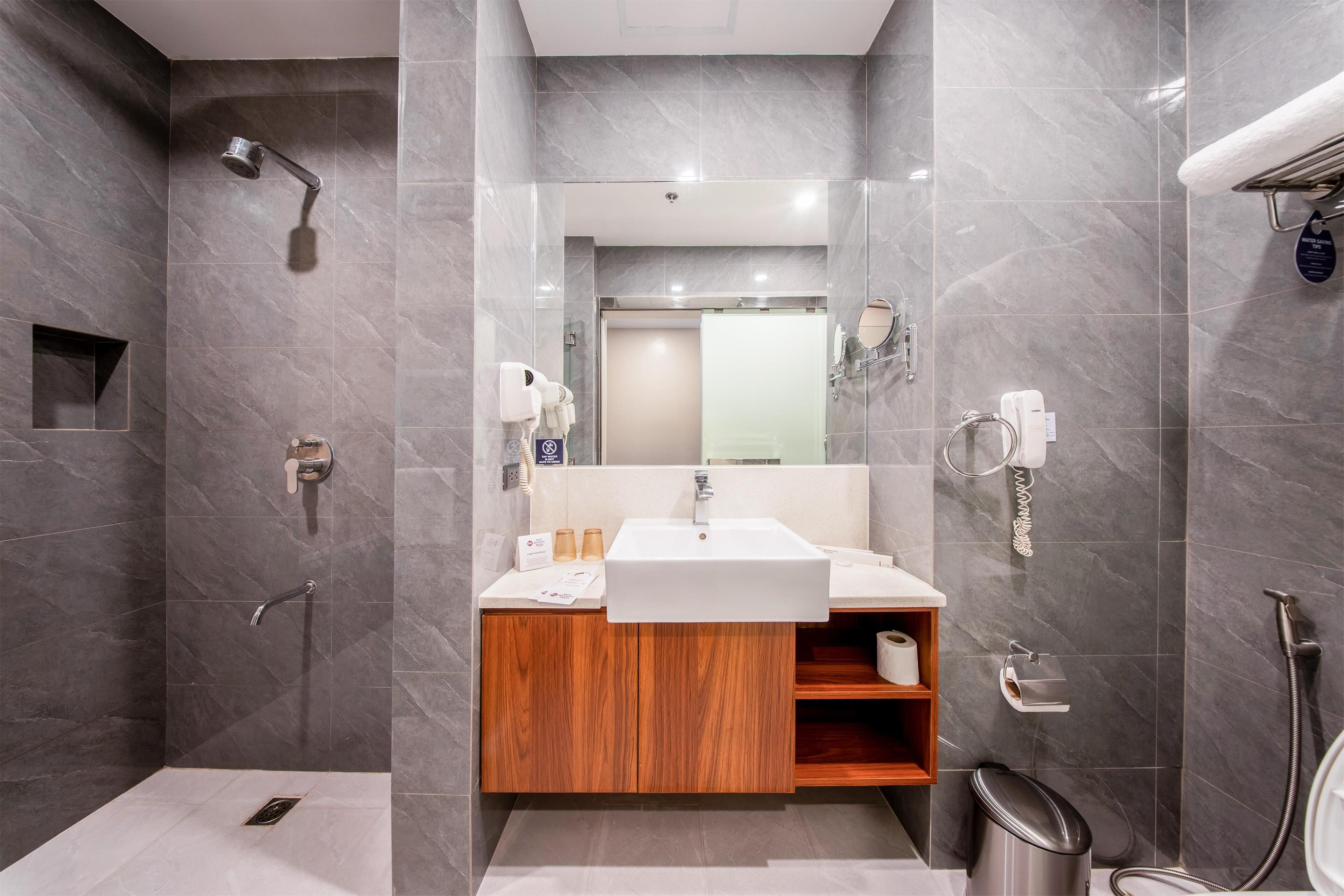 A modern bathroom with a shower, sink, and vanity.