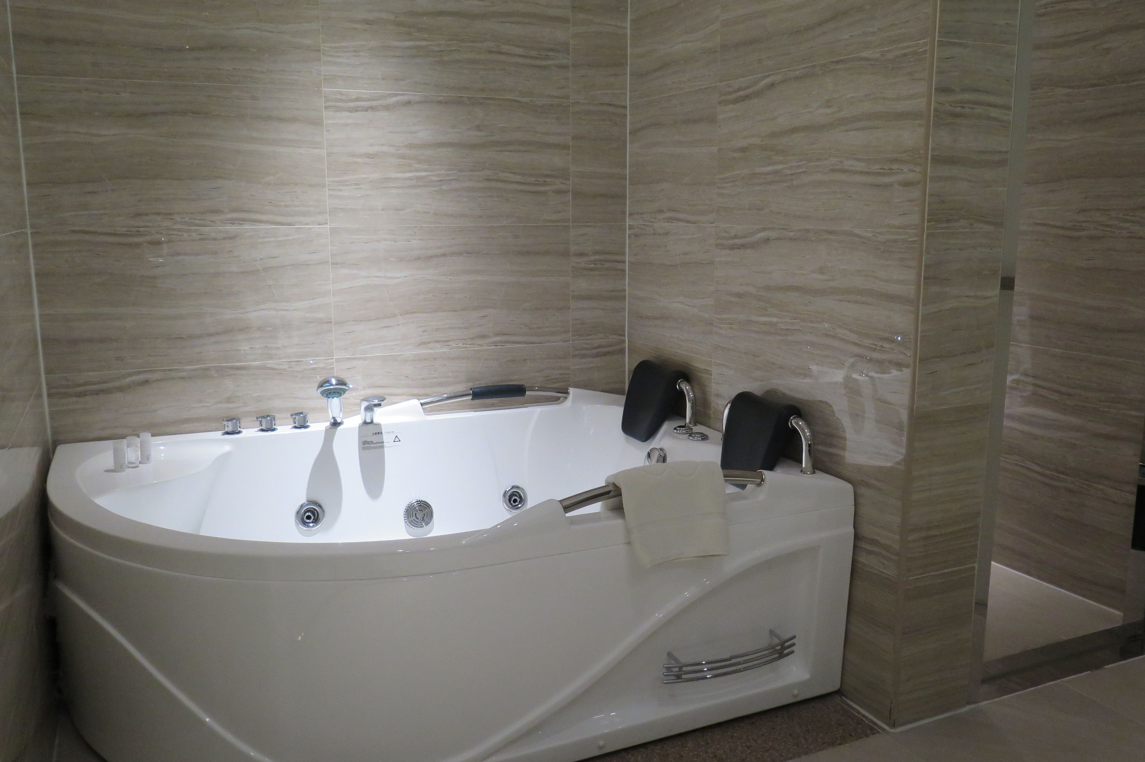 Une salle de bain moderne avec une baignoire sur pieds, un porte-serviettes et un espace douche intégré.