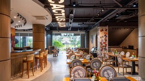 A modern restaurant with a bar area, wooden tables, and chairs. - Best Western Plus Hotel Subic (Olongapo)