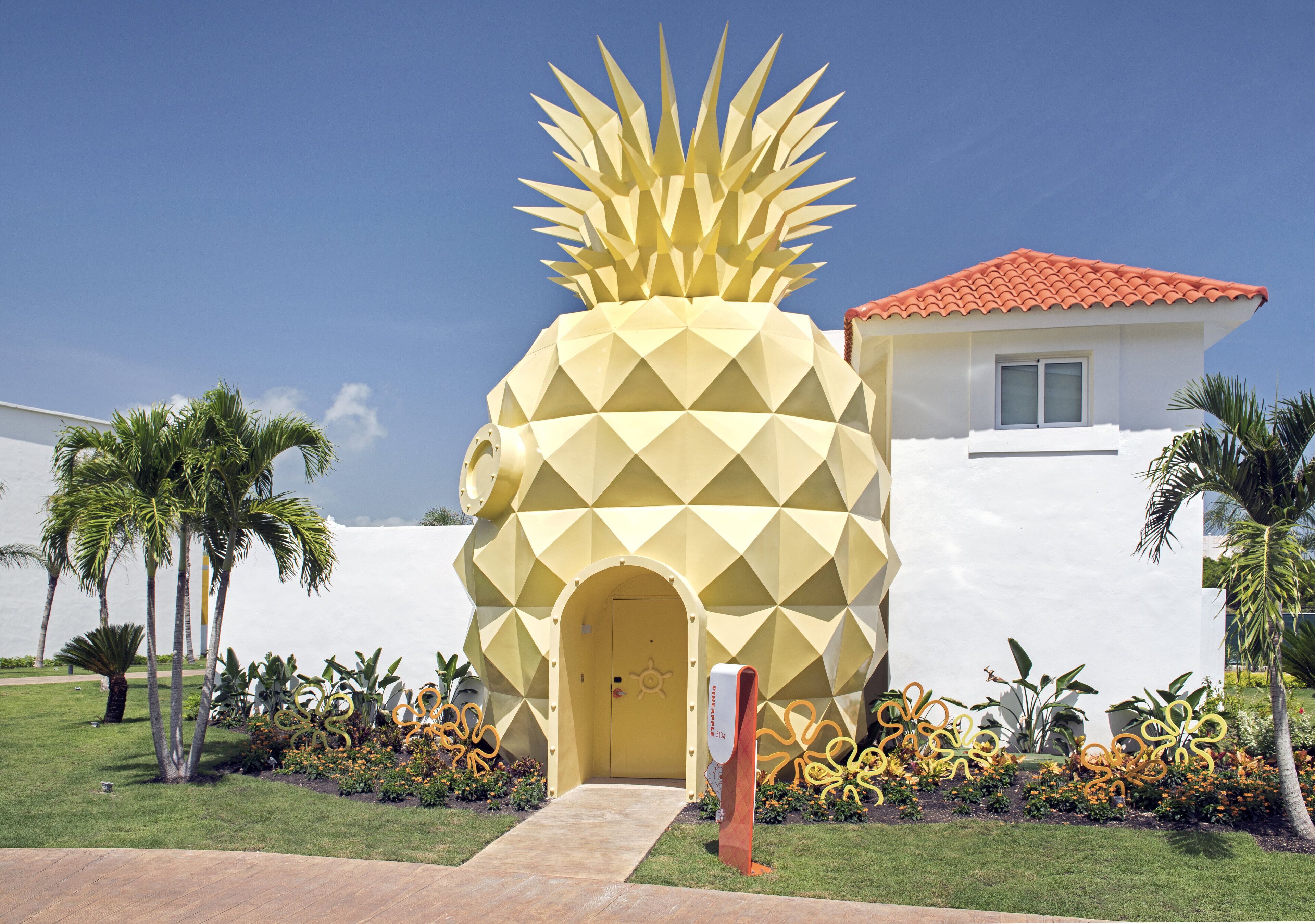 Een gebouw met een ananasshaped entree en een rode pannendak.