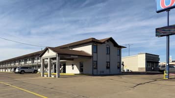 Guests can check in at this single-story motel with a covered entrance and staircase leading to the upper level.
