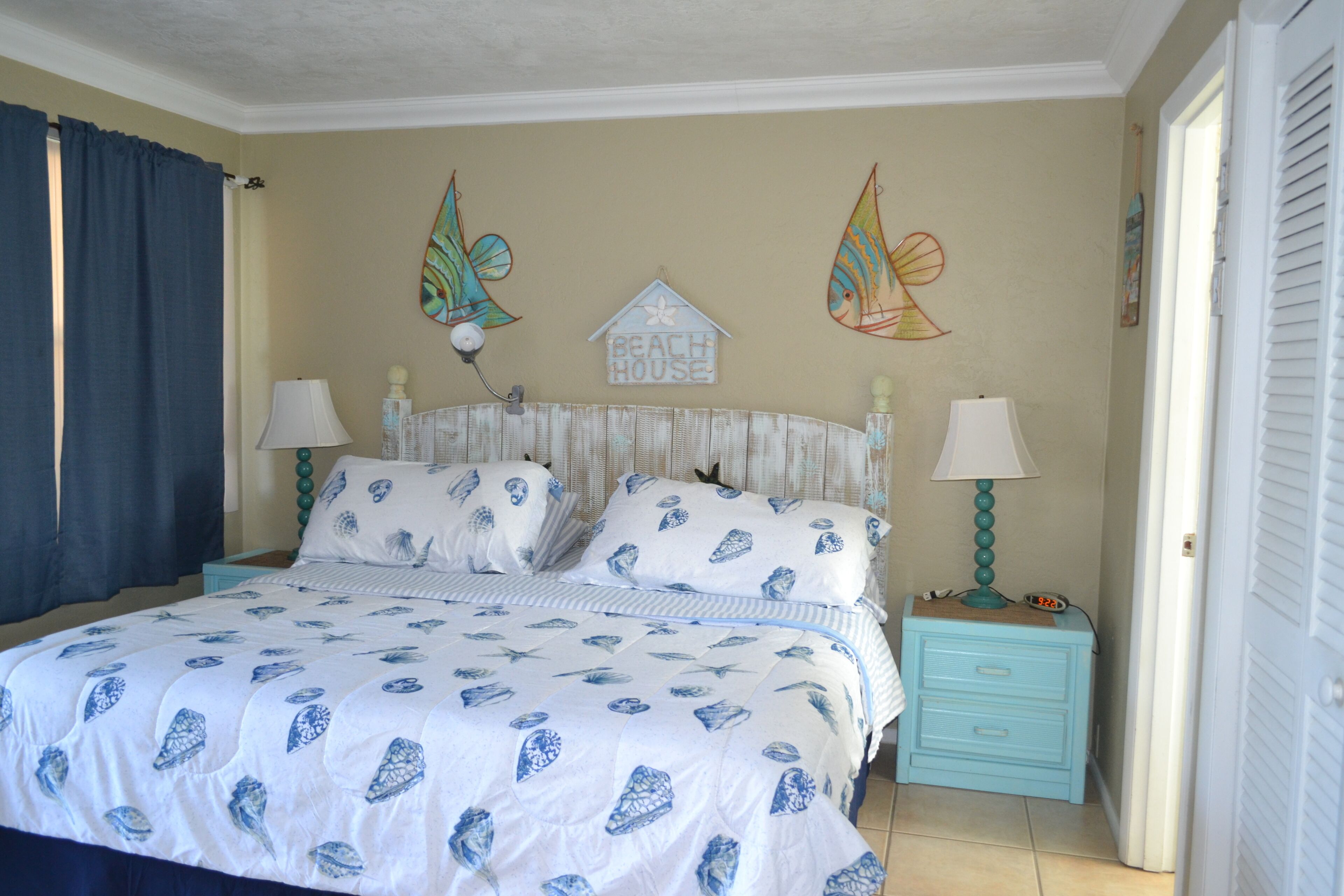 A bedroom with a bed, two nightstands, and decorative wall art.