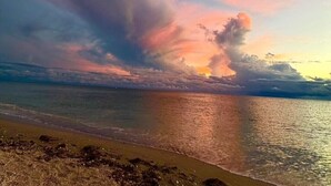 A beach with a sunset and clouds. - Sun Life Beach Hotel (Englewood)