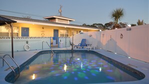 A swimming pool with a clear water surface, a lifeguard stand, and a few lounge chairs. - Sun Life Beach Hotel (Englewood)