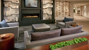 Ein modernes Wohnzimmer mit Kamin, grauen Sofas und einem Bücherregal.