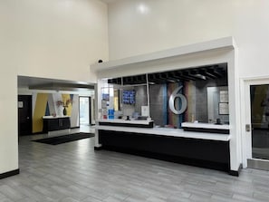 Zona de recepción con mostrador, un cartel grande con el número 6 y un diseño interior moderno.