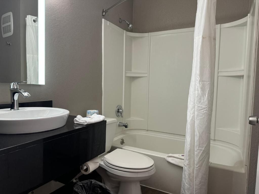 A bathroom with a sink, toilet, and bathtub.